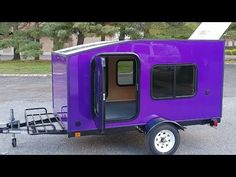 the purple trailer is parked in the parking lot with it's door open and windows closed