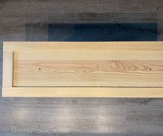 a wooden sign sitting on top of a hard wood floor