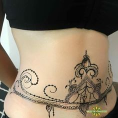 a woman's stomach with henna tattoos on it and the bottom part of her belly