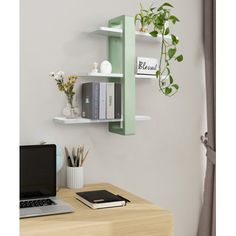 a laptop computer sitting on top of a wooden desk next to a plant and bookshelf