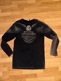 Harley Davidson shirt  - Rare  - Y2K streetwear  - Big eagle graphic  - Juneau Alaska  - Taku spell out  - Crossfade black/gray colourway  Size: Large (slim fit) 21" pit to pit  31.5" shoulder to waist  Good used condition  No rips or holes  No stains Black Long Sleeve Top With Graphic Design, Black Long Sleeve Tops With Screen Print, Urban Long Sleeve Tops With Logo Print, Washed Black Graphic Print Tops For Streetwear, Urban Long Sleeve T-shirt With Front Print, Black Long Sleeve Shirt With Screen Print, Grunge Long Sleeve T-shirt With Graphic Print, Black Biker Tops For Winter, Winter Black Graphic Design T-shirt