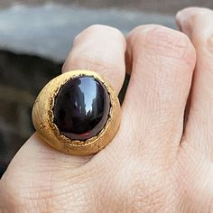 Measuring approx. 11mm wide, centering an oval cabochon garnet measuring approx. 16 x 12 mm., fashioned in 18k yellow gold. Size 4. Garnet Ring Vintage, Ruby Diamond Rings, Coral Ring, Garnet Ring, Ruby Diamond, Garnet Rings, Oval Cabochon, Antique Rings, Vintage Rings