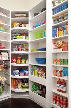 an organized pantry with white shelving and lots of food on the shelves in it