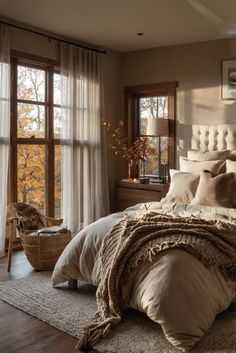 a large bed sitting in a bedroom next to a window covered in blankets and pillows