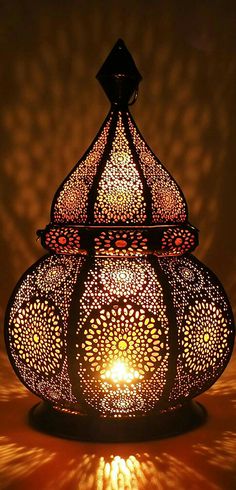 an intricately designed lamp is lit by the light coming from it's top