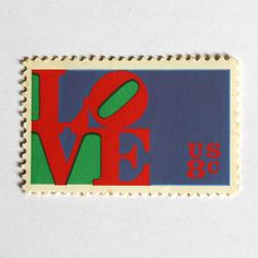 a postage stamp with the word love written in red, green and blue on it