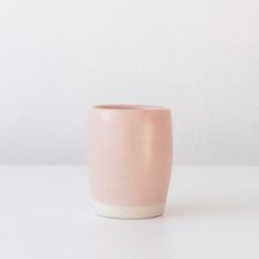 a pink cup sitting on top of a white table