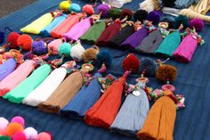 many different colored pom poms are laying on a table with other items in the background