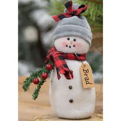 a snowman with a hat and scarf on it's head is sitting on a table