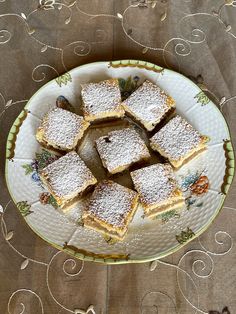 a white plate topped with lots of desserts on top of a cloth covered table