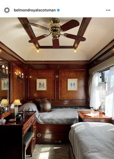 a bedroom with two beds and a ceiling fan in the corner next to a window