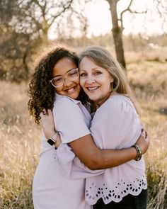 two women hugging each other in a field