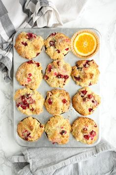 muffins and an orange on a baking sheet