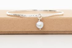 Beautiful handmade hammered sterling silver bangle with a stunning grey baroque fresh water pearl. The bracelet is 65mm in circumference and the pearl measures between 8mm.  Simple yet striking this is great of everyday wear. The bangle makes a lovely birthday gift and a great present for a bridesmaid to remember your special day by. This elegant bracelet will come beautifully packaged in a gift box with ribbon. The perfect gift or simply treat yourself. Please visit my shop to see my full range of bangles. https://www.etsy.com/shop/Joonthemoon1?ref=si_shop Sterling Silver Hammered Bangle As Gift, Sterling Silver Hammered Bangle For Gift, Minimalist Silver Hammered Bangle, Minimalist Hammered Silver Bangle, Hammered Sterling Silver Bangle Bracelet Gift, Elegant Hammered Sterling Silver Bangle Bracelet, Elegant Hammered Sterling Silver Bangle, Adjustable Hammered Bangle For Wedding, Adjustable Hammered Wedding Bangle