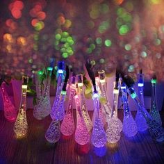 there are many different colored lights in the glass vases on the table with each other