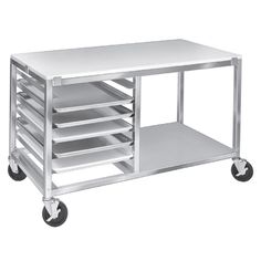 a white table with several trays on wheels and one shelf holding various items in it