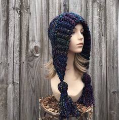 "Crochet Hat Style: Bonnet style hood with fluffy oversized tassels. Color: This sample hat is shown in City Lights, a navy blue base with rainbow colors. Sizes: One size fits 20\" to 23\" (50.5 cm to 58 cm) head size. Fiber Content: 80% acrylic, 20% wool Characteristics: Whimsical, very soft, warm and cozy.  Care Instructions: Hand wash, dry flat.  Every item from Pixiebell is handmade and knit or crocheted to order, unless otherwise stated in title of the item as \"ready to ship\". Production time may vary, please check the SHIPPING & POLICIES tab for accurate processing times. If you need an item promptly, please contact us so that we can make arrangements.  While every effort is made to accurately represent the true colors of the yarns used in our work, your monitor settings may affect Winter Bohemian Yarn Bonnet, Bohemian Yarn Bonnet For Winter, Bohemian Winter Bonnet, Bohemian Yarn Hats For Winter, Bohemian Yarn Beanie For Winter, Winter Bohemian Yarn Hat, Bohemian Winter Yarn Beanie, Bohemian Hand Knitted Bonnet For Winter, Bohemian Hats For Cold Weather And Fall