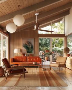 a living room filled with lots of furniture and large windows overlooking the trees in the distance