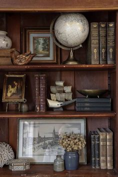 an old book shelf with books, pictures and other items on it's shelves