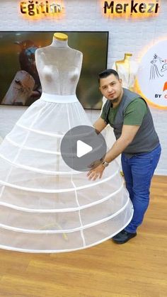 a man standing next to a white dress on display