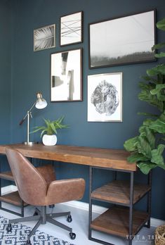 a home office with blue walls and pictures on the wall, including a leather chair