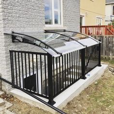 a glass and metal railing on the side of a house in front of a brick building