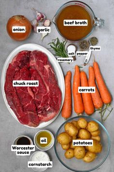 the ingredients for beef stew laid out on a table with carrots, potatoes and broth