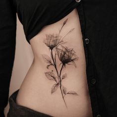 a woman's stomach with a flower tattoo on it