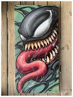 a painting of a monster with fangs on it's face and mouth is hanging from a wooden fence