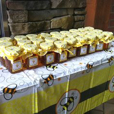 a table topped with lots of honey covered boxes next to a fire place filled with candles