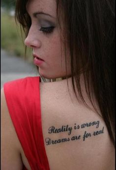 a woman with a tattoo on her back saying reality is very dreams are for real