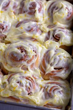 a baking dish filled with cinnamon rolls covered in icing