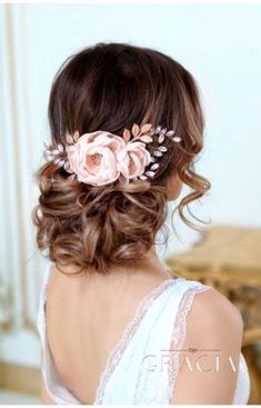 a woman with flowers in her hair is wearing a white dress and has long brown hair