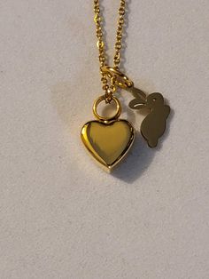 a gold necklace with a heart and a bunny on it