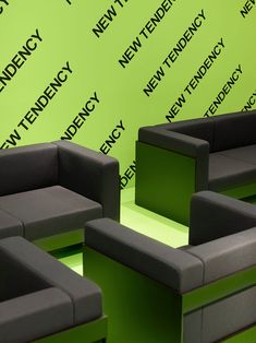 several couches and chairs are arranged in front of a green wall with the words new tendency on it