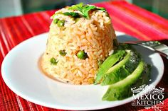 a plate with rice, peas and avocado on it