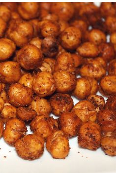 roasted chickpeas on a white plate with brown flecks and seasoning