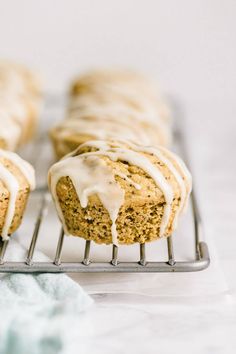 three muffins with icing sitting on a cooling rack