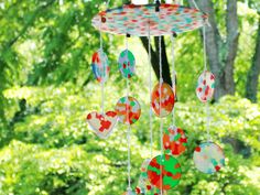 a wind chime hanging in the middle of a forest with lots of green trees