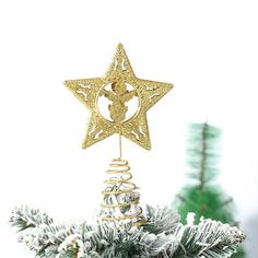 a gold star ornament hanging from a christmas tree in front of a white background