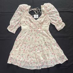 Light Creme And Pink Floral Mini Dress, It Has A Surplice Neckline, Open Back With Self-Tie Support Strap, 3/4 Puff Sleeves, Ruching At The Waist And Back Panel, Ruffled Trim, A Tiered Hem, And Concealed Back Zipper For Size, The L Fits More Like A M And The Xl Fits More Like A L Forever 21 Short Sleeve Dress For Brunch, Forever 21 Spring Dress, Flirty Forever 21 Dress For Brunch, Feminine Fitted Dress From Forever 21, Flirty Spring Dresses By Forever 21, Flowy Ruffled Dresses From Forever 21, Forever 21 Casual Spring Dress, Fitted Feminine Dress By Forever 21, Forever 21 Feminine Mini Dress For Spring