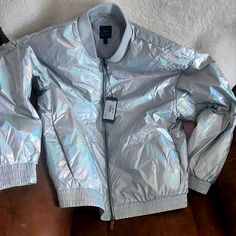 Description Strong In Style, This Light Weight Shiny Nylon Jacket Takes A Classic Jacket Style And Reinvents It In True A|X Fashion. Designed With A Shiny, Light Weight Fabric, This Jacket Is Made Complete With The Iridescent Logo Patch On The Back. Details Composition 100% Polyamide Light Weight Shiny Laminated Nylon Jacket Bomber Silhouette Iridescent Logo Patch Fabric: 100% Polyammide Imported Product Iridescent Fitted Long Sleeve Outerwear, Fitted Iridescent Outerwear For Winter, Fitted Iridescent Outerwear For Fall, Trendy Iridescent Outerwear For Fall, Casual Iridescent Long Sleeve Outerwear, Pilot Jacket, Black Faux Leather Jacket, Classic Jacket, Black Logo