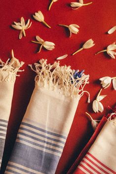 three towels are lined up next to each other on a red surface with white flowers