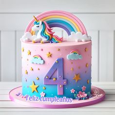 a birthday cake with a unicorn on top and rainbows in the sky around it