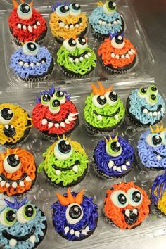 cupcakes decorated with colorful icing and eyes are in a plastic container on the table