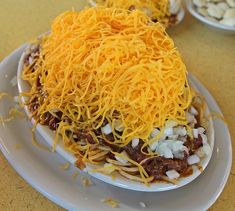 a white plate topped with lots of cheese and other toppings on top of it