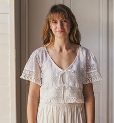 One-of-a-kind top made in vintage lace. Size - Small, UK size 10 (US size 6) Bust: 35"/89cm, Waist: 29"/73cm This top is re-cycled - handmade from an off-white vintage cotton lace tablecloth with a new cotton lace trim (remnants from my bridal collection). It has a low V-neckline at the front with 2 ties and loose short sleeves. This item is re-cycled and by it's nature delicate. I closely inspect all items and try to only use the best parts of a cloth but there may be tiny flaws and signs of it Cotton Tops With Lace Trim For Weddings, Summer Wedding Tops With Lace Work, Wedding Tops With Lace Work And Short Sleeves, Bohemian Broderie Anglaise Lace Top For Summer, White Broderie Anglaise Top For Wedding, Cropped Lace Tops With Lace Trim, Bohemian Cotton Top For Wedding, Lace Tops With Broderie Anglaise For Wedding, White Crochet Top For Summer Wedding