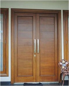 the front door to a house with two wooden doors and sidelights on each side