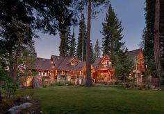 a large house surrounded by trees in the evening