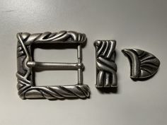 two metal buckles with decorative designs on them